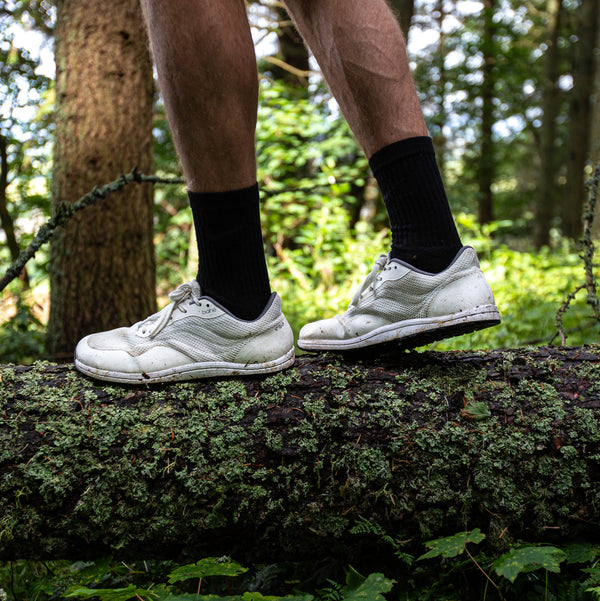 Bahé Revive barefoot style shoe in Frost (white) on a man walking on log
