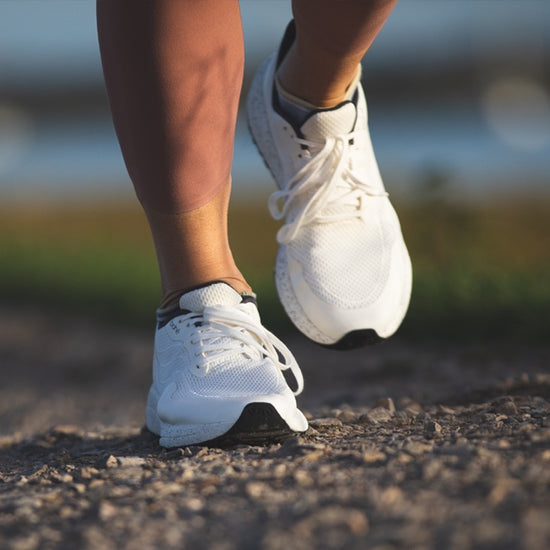 Close up of woman walking in Bahé Recharge grounding shoes in white (frost)