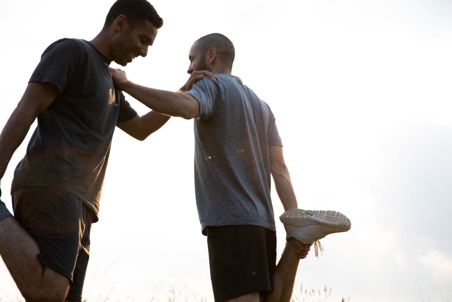 Bahé founders Alex Ward and Kishan Bharwad stretching in nature wearing Bahé Recharge Grounding shoes