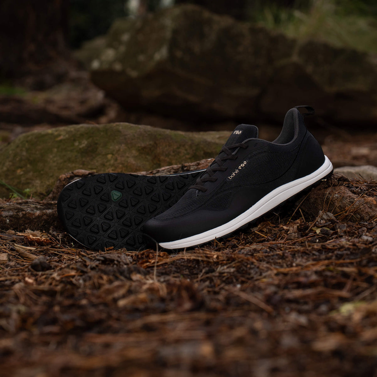 Black sneakers with white soles on a natural background