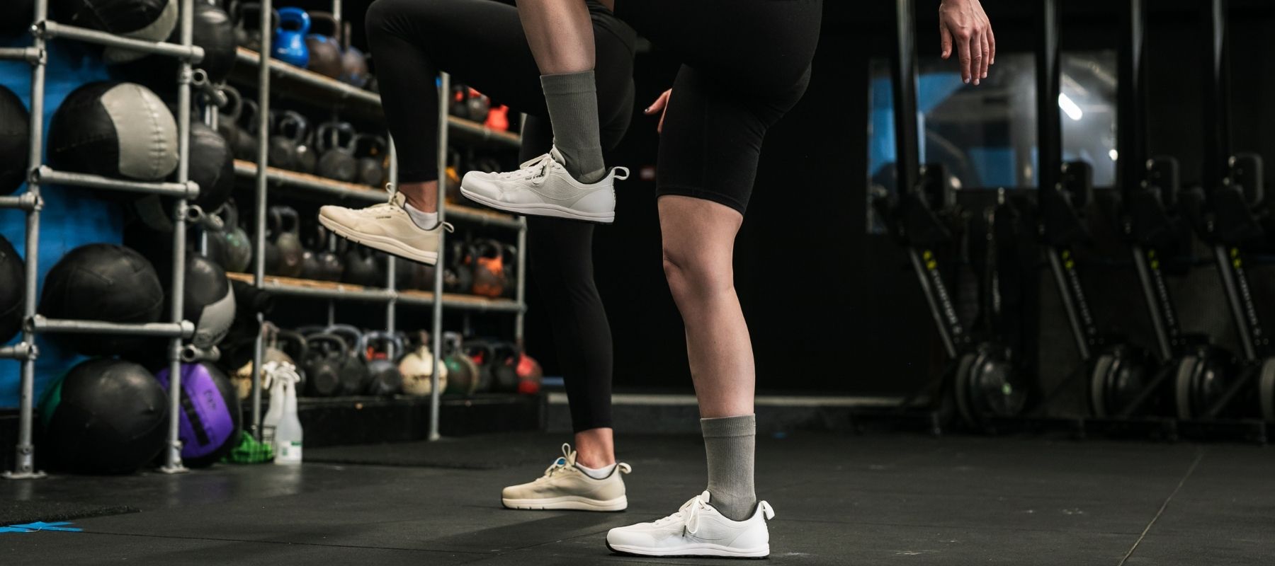 Person exercising in a gym with weights and exercise equipment in the background