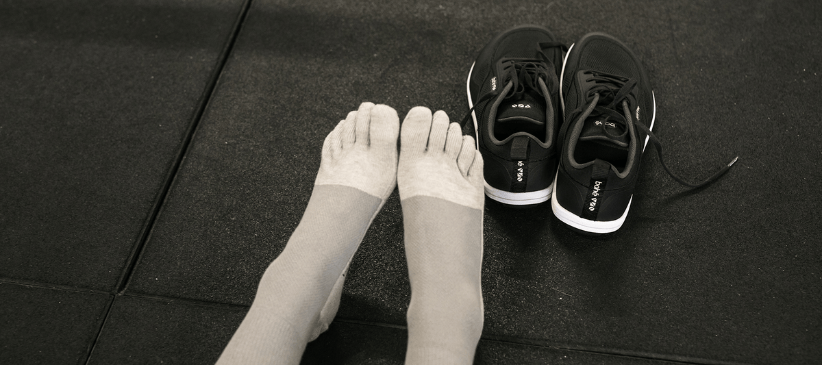 Feet in toe socks next to Bahé shoes