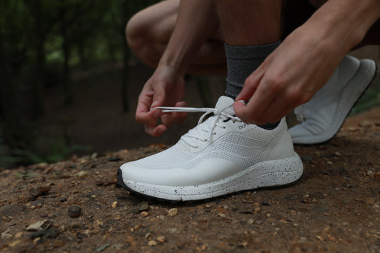 Bahé Recharge shoes in Frost (white) laces being tied in nature