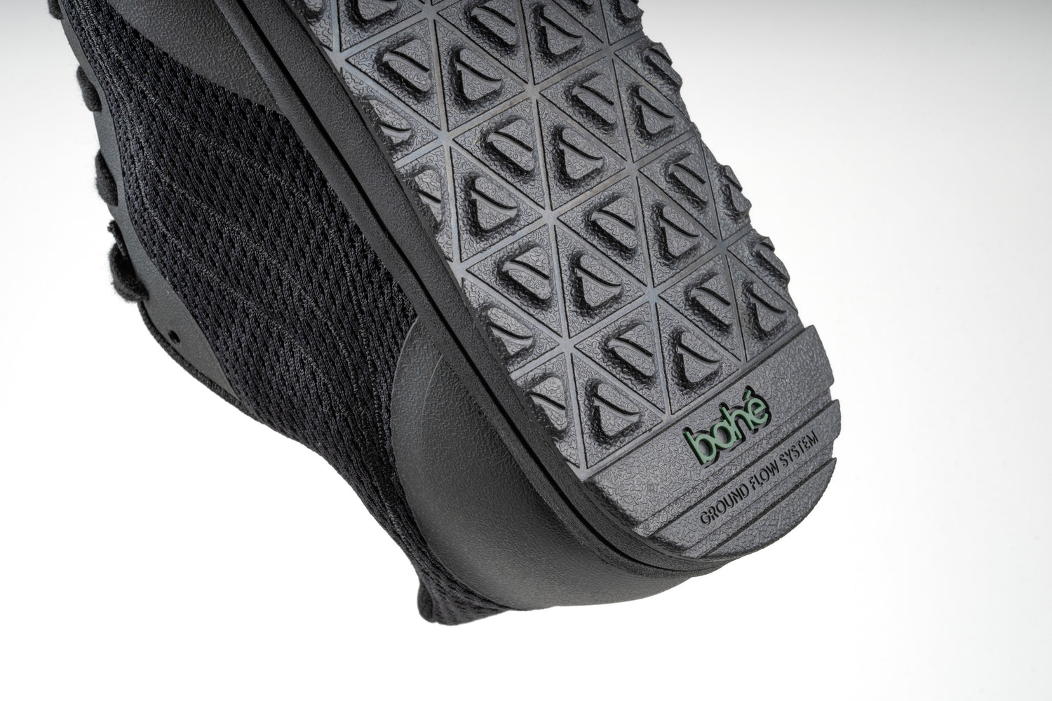 Close-up of 'ground flow system' word mark debossed on outsole of Bahé Revive barefoot style grounding shoes in Eclipse (black)