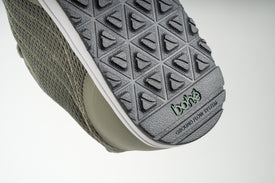 Close-up of 'ground flow system' word mark debossed on outsole of Bahé Revive barefoot style grounding shoes in Forest (green)