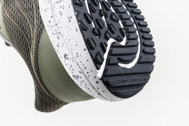 Close-up of 'ground flow system' embossing on outsole of Bahé Recharge grounding shoes in Forest (green)