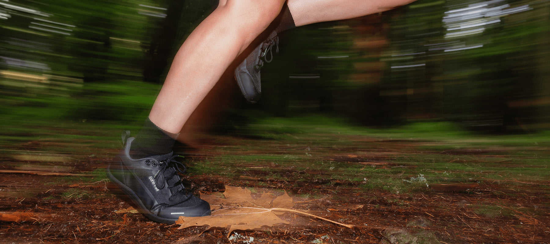 Person running on a forest trail in Bahé Rewild with blurred motion effect