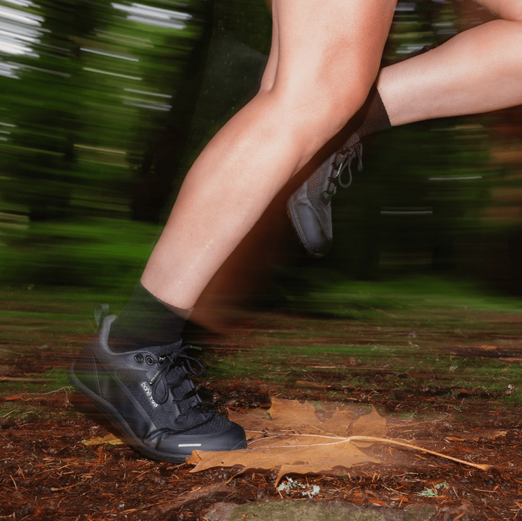 Person running on a forest trail in Bahé Rewild with blurred motion effect