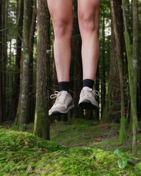 Person's legs in Bahé  shoes jumping in a forest setting