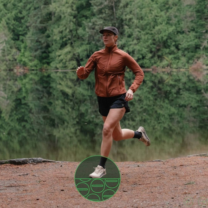 Person running on a trail with a forest in the background