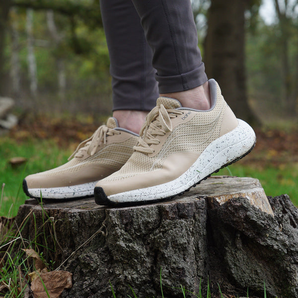 Bahé Recharge grounding shoes in Sandstone (beige) worn by woman on log