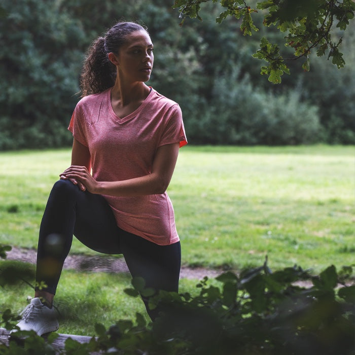 Woman exercising in nature wearing Bahé Recharge grounding shoes