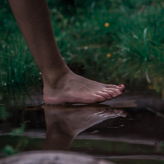 barefoot woman grounding in nature