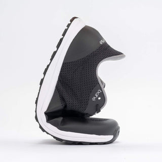 Black and white shoe with a visible brand logo on a light gray background