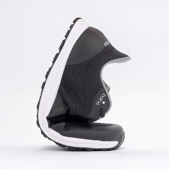 Black and white shoe with a visible brand logo on a light gray background