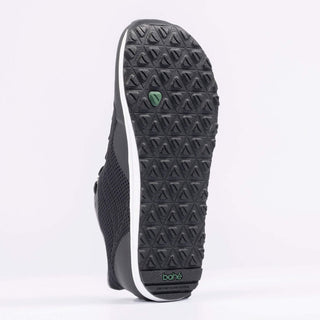 Black sneaker with textured sole on a white background