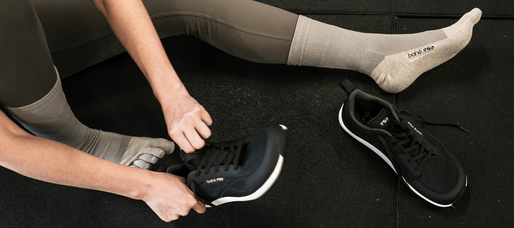 Woman putting on Bahé Revive Flex Midnight Grounded Training Shoe