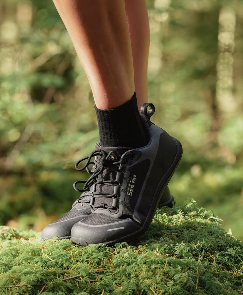 Person wearing Rewild Eclipse Trail Shoes on a green, natural background